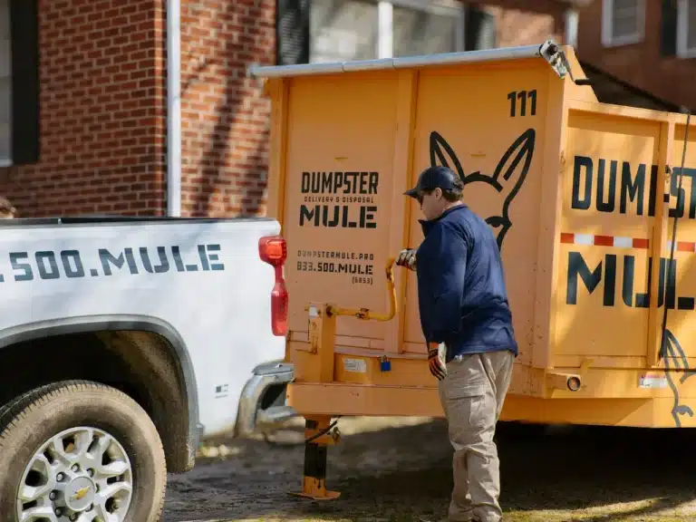 Ted Dunn unhitching the dumpster trailer to carefully place in a customer driveway